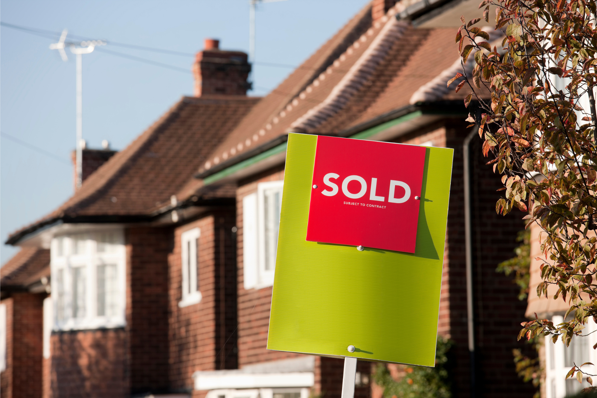 A sold placard outside of a row of houses