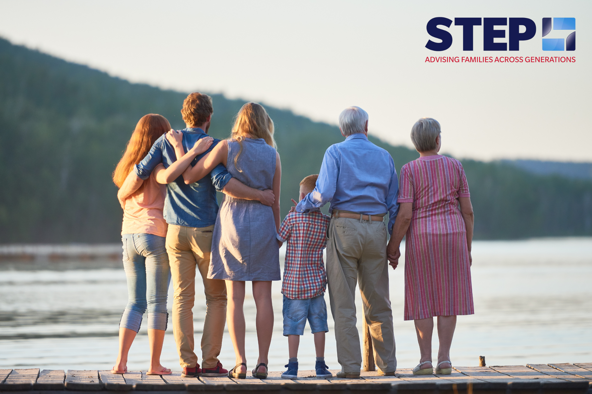 Several generations of 1 family are seen together looking out over a lake.